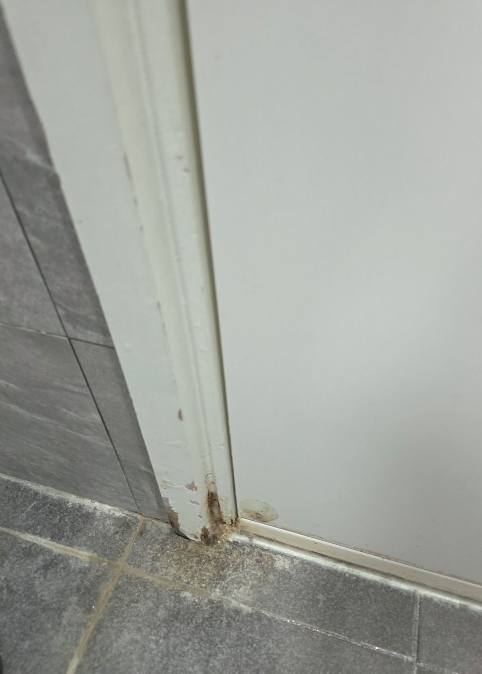 영등포 방문수리 시공 전 — 문틀 하부에 물 자국이 번지고 도장면이 벗겨진 상태